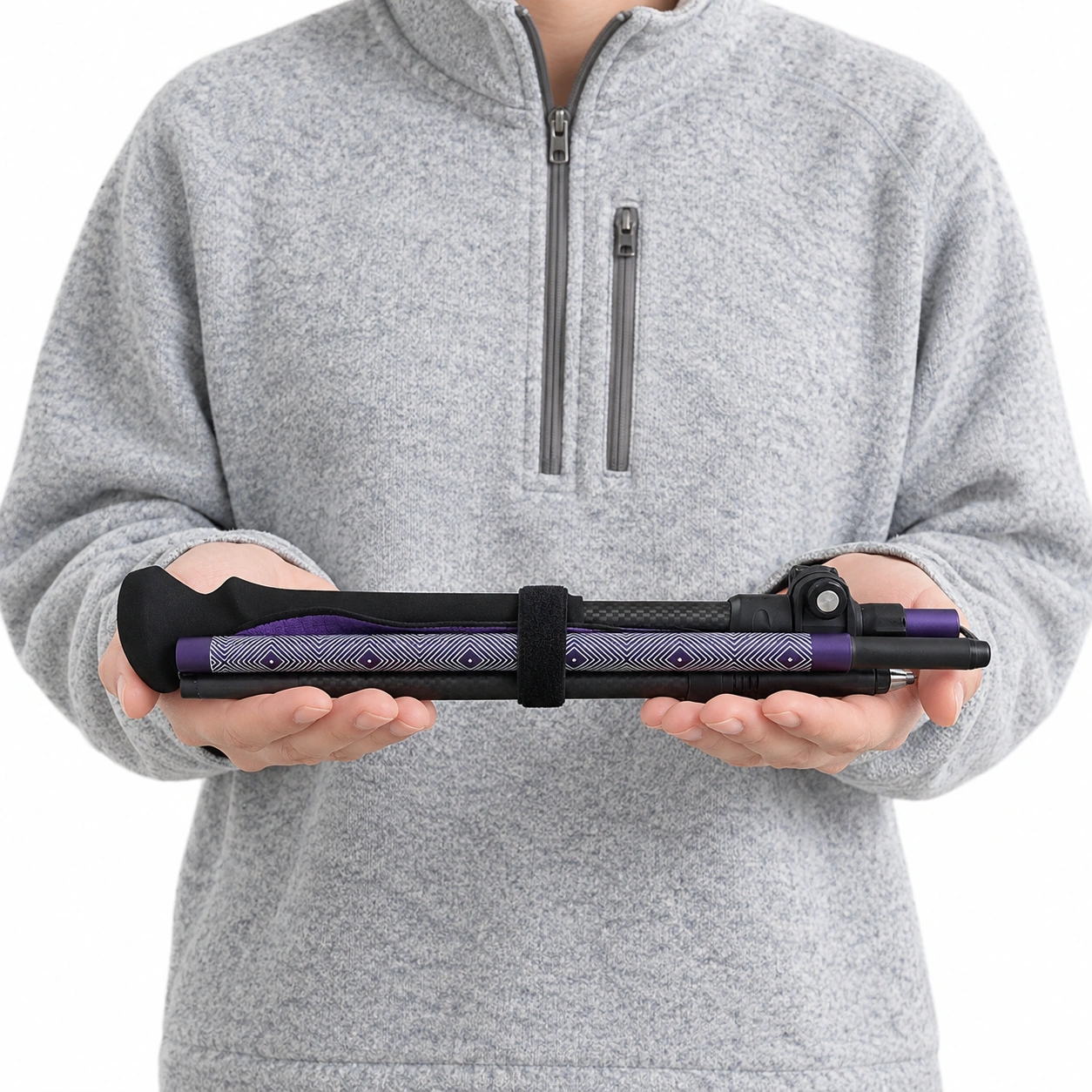 A folded Purple Cirrus Carbon trekking pole held in both hands.